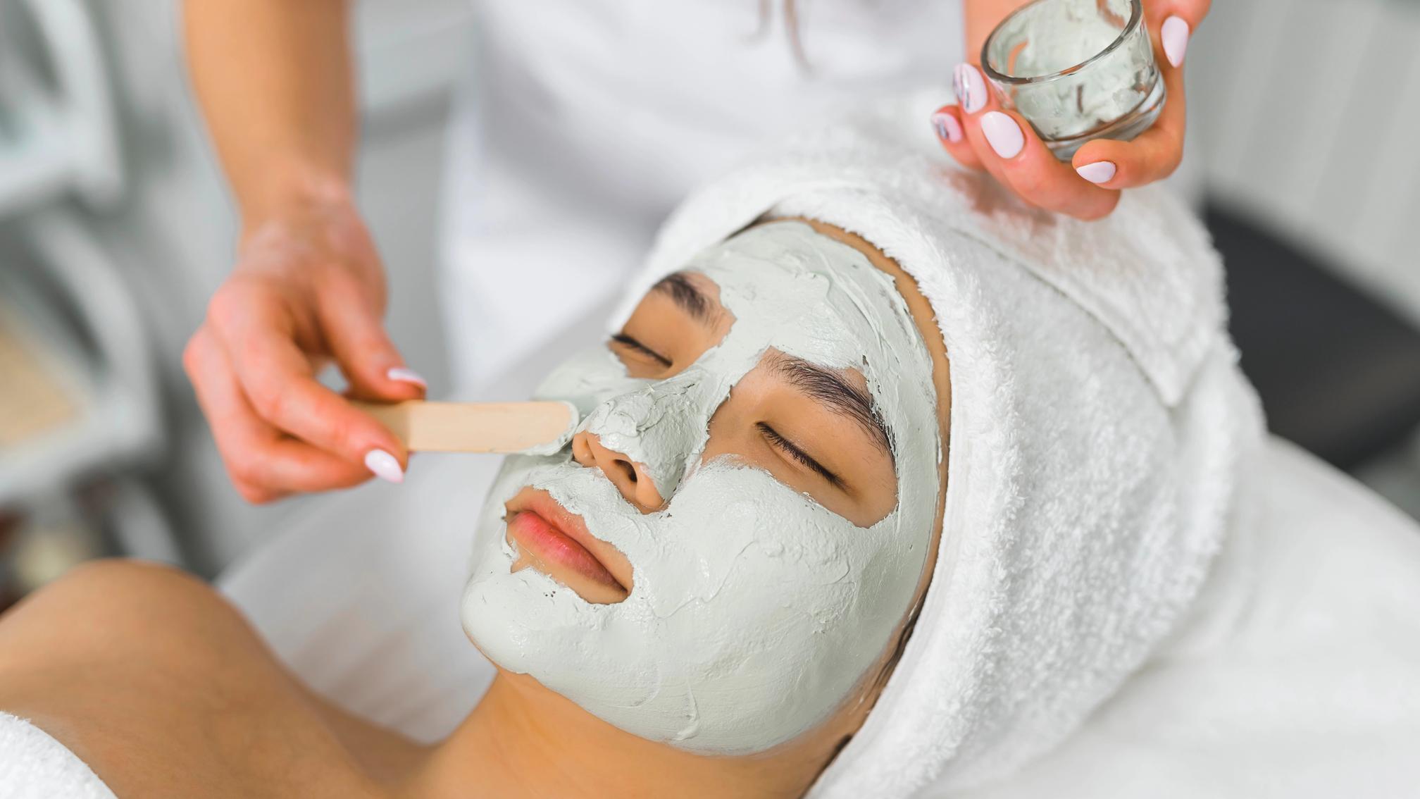 Woman receiving a facial mask skincare treatment at a med spa
