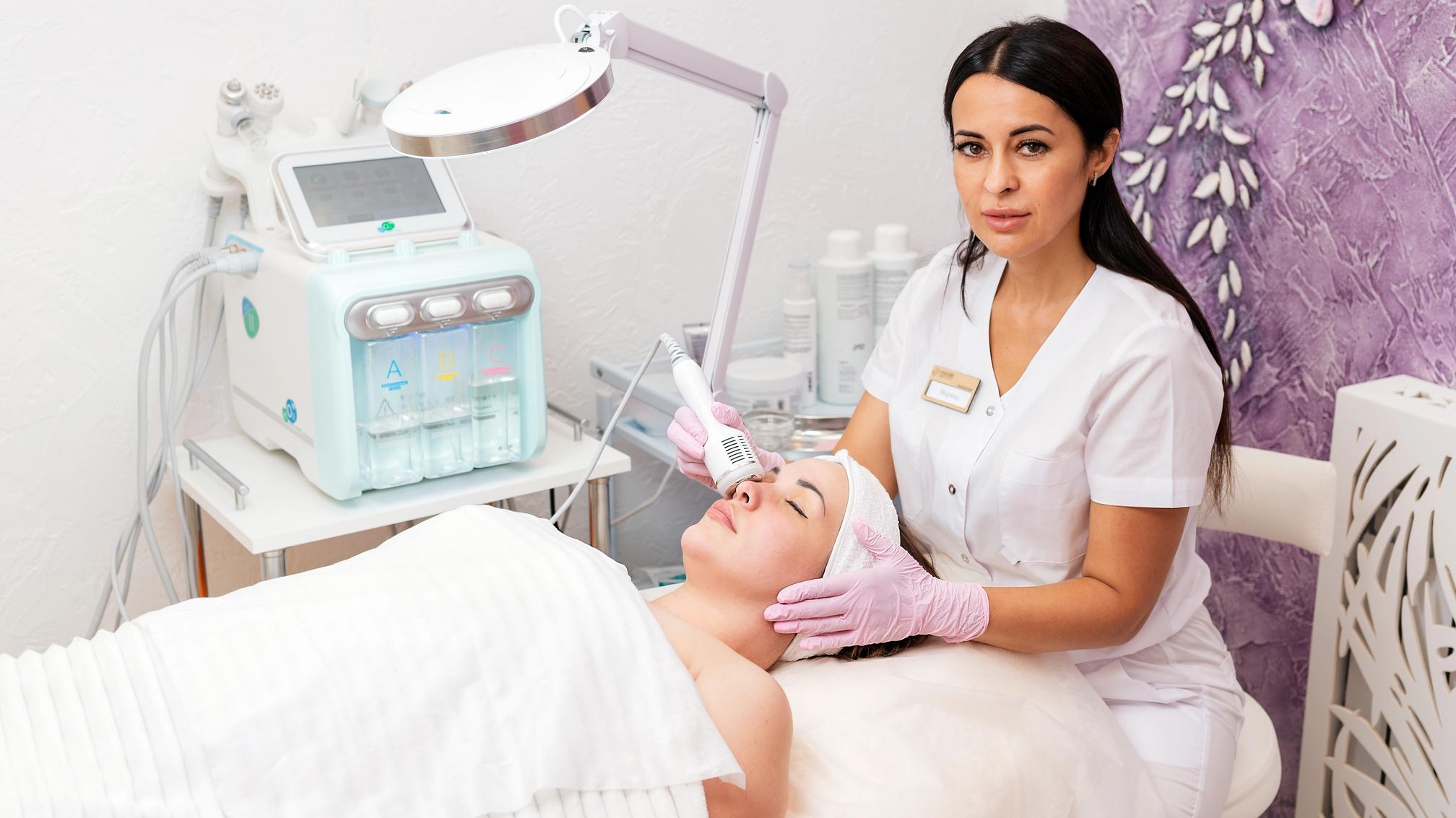 Esteticista realizando un tratamiento HydraFacial a una clienta