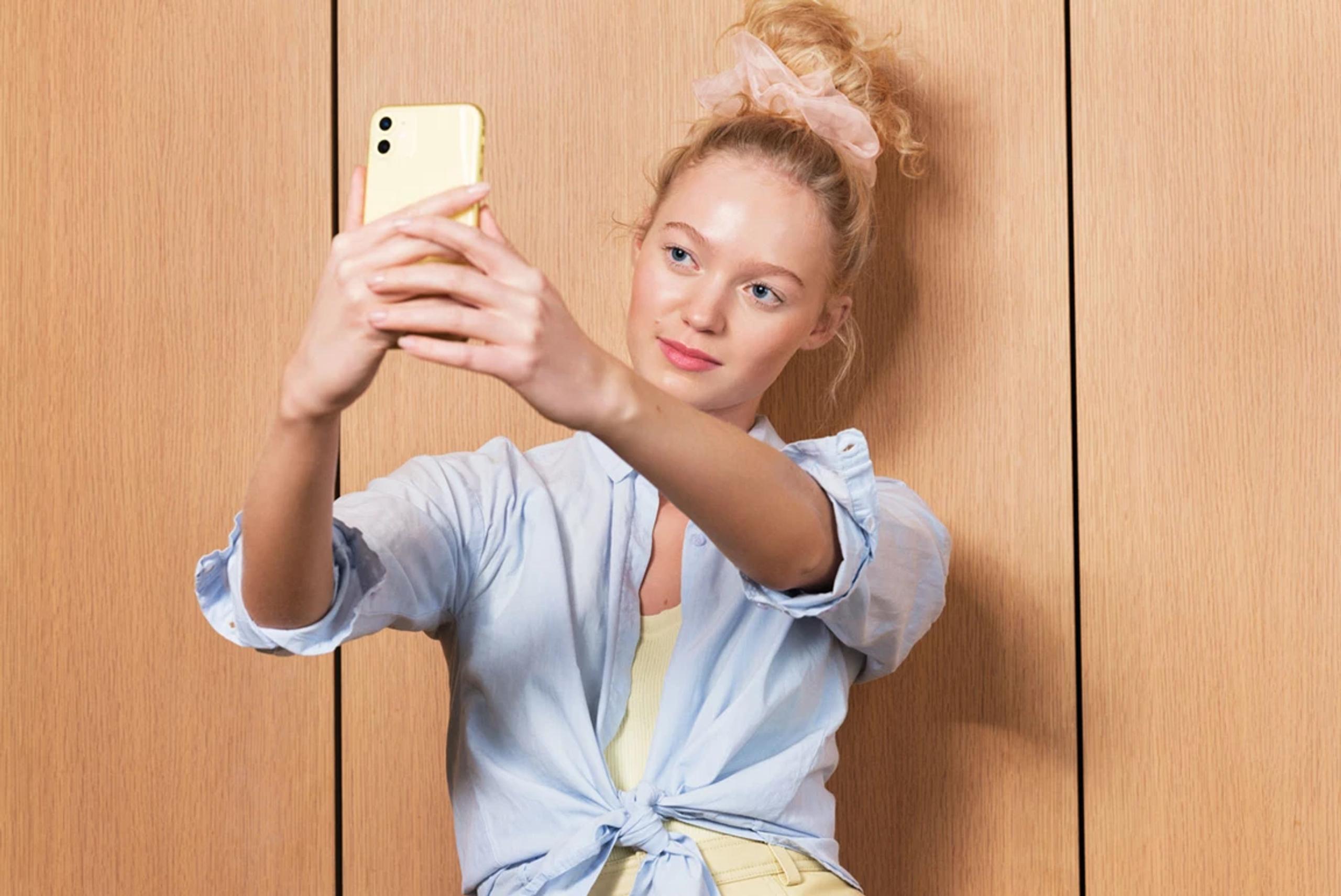 Ung kvinne tar selfie med mobilen