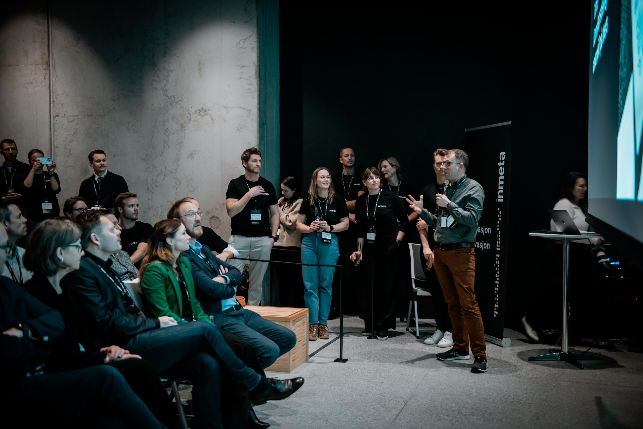 Inmeta-konsulent presenterer løsning foran publikum på Inmeta og Eidsiva Hackathon 2024 i Nydalen