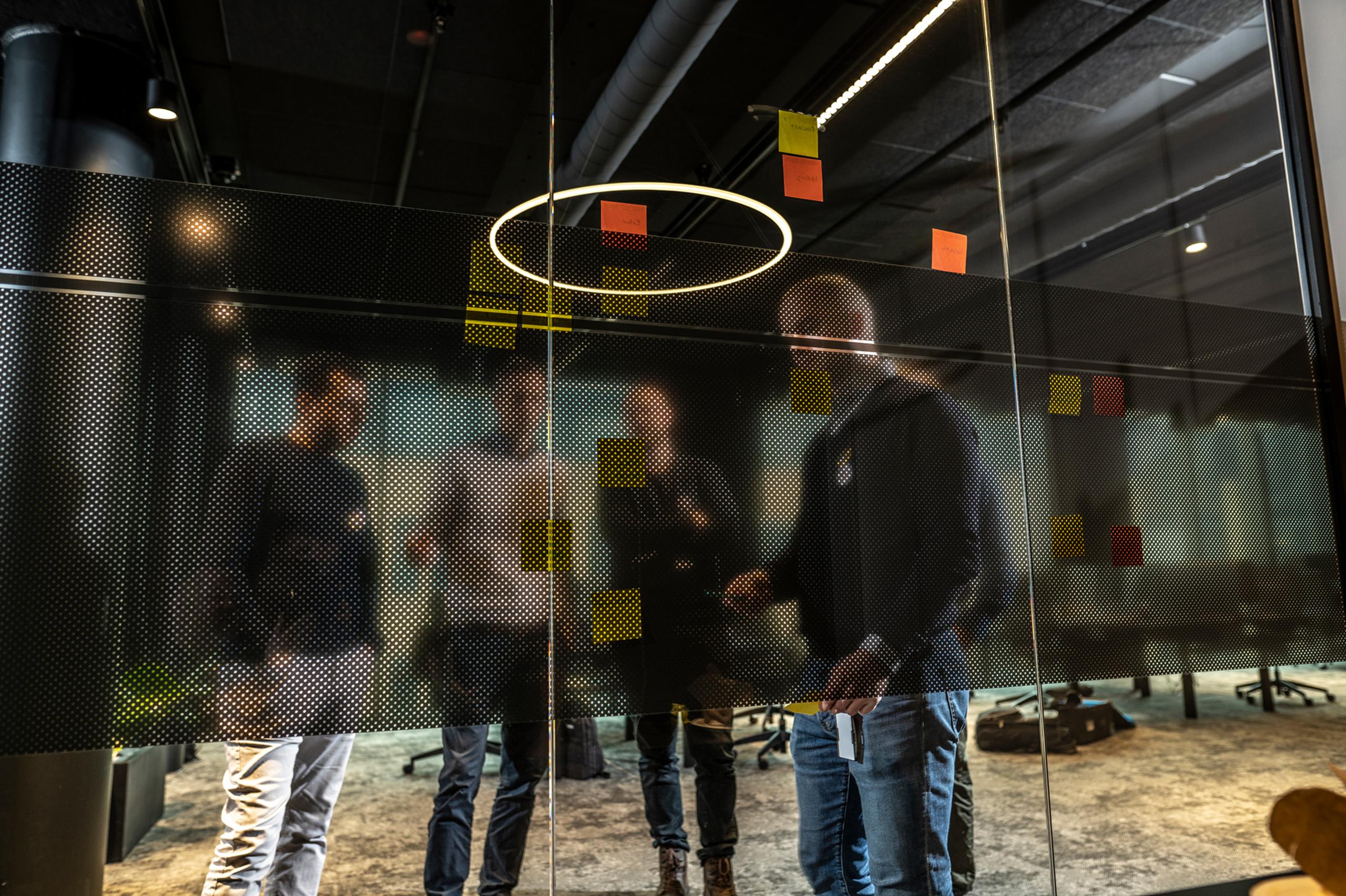 fire inmeta-konsulenter på oslo-kontoret foran vegg med post-it lapper