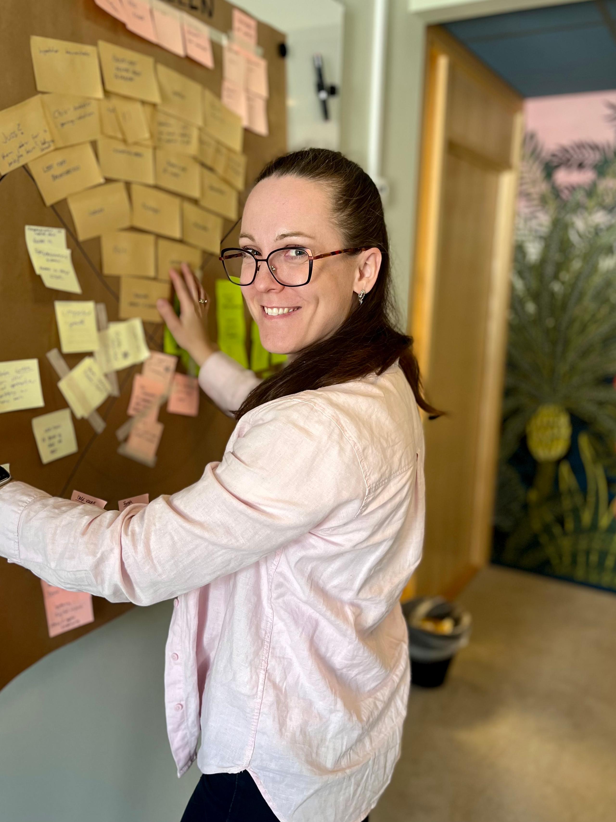 Anna Rabstad på Hamar-kontoret foran tavle med post-its