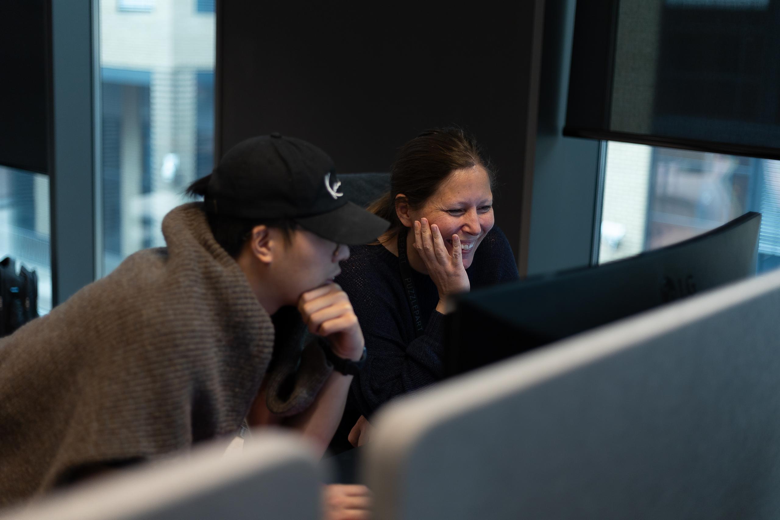 Tin Hoang Vu og Torill Svantorp sitter sammen ved en pc-skjerm
