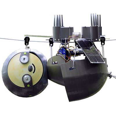 The SlothBot robotic sloth hangs upside down from a wire. It has a solar panel and other electronics.
