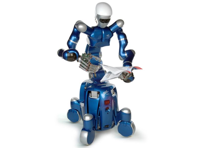 A shiny blue and silver humanoid with two long arms with silver hands and a four wheeled mobile base holds a newspaper.