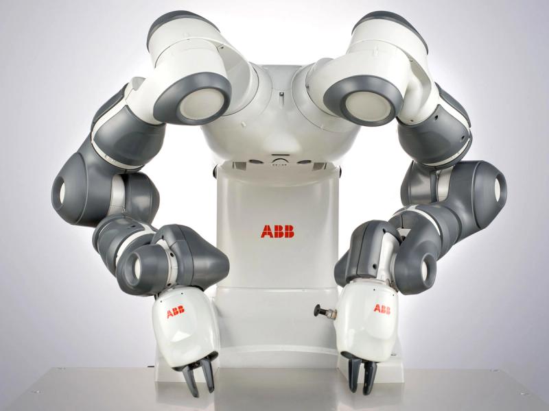 A dextrous two-armed collaborative robot with a white torso on a base labelled ABB in red letters. It's two powerful industrial arms end with two finger grippers on small box-like palms.