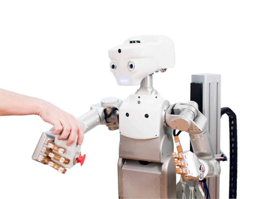 A human hand on the robot's arm shows a big red button.