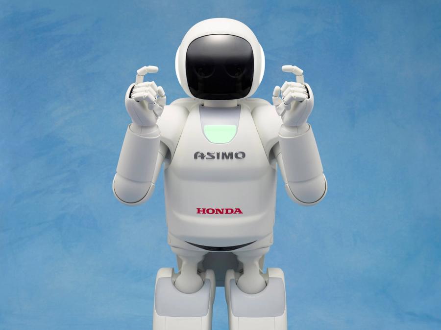 A human shaped robot labelled Asimo holds its fingers up.