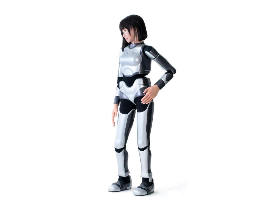 Full body front view of the robot. Its body is encased in a silver and black covering, but it's hands and face have the appearance of flesh.