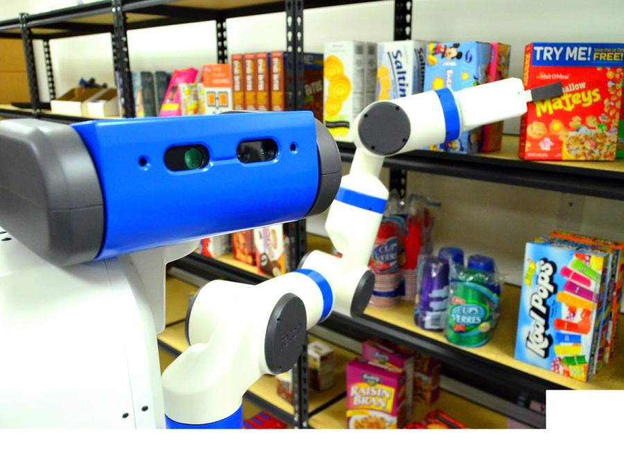 Close up of a robot positioning it's articulated arm to grip a box of cereal from a shelf.