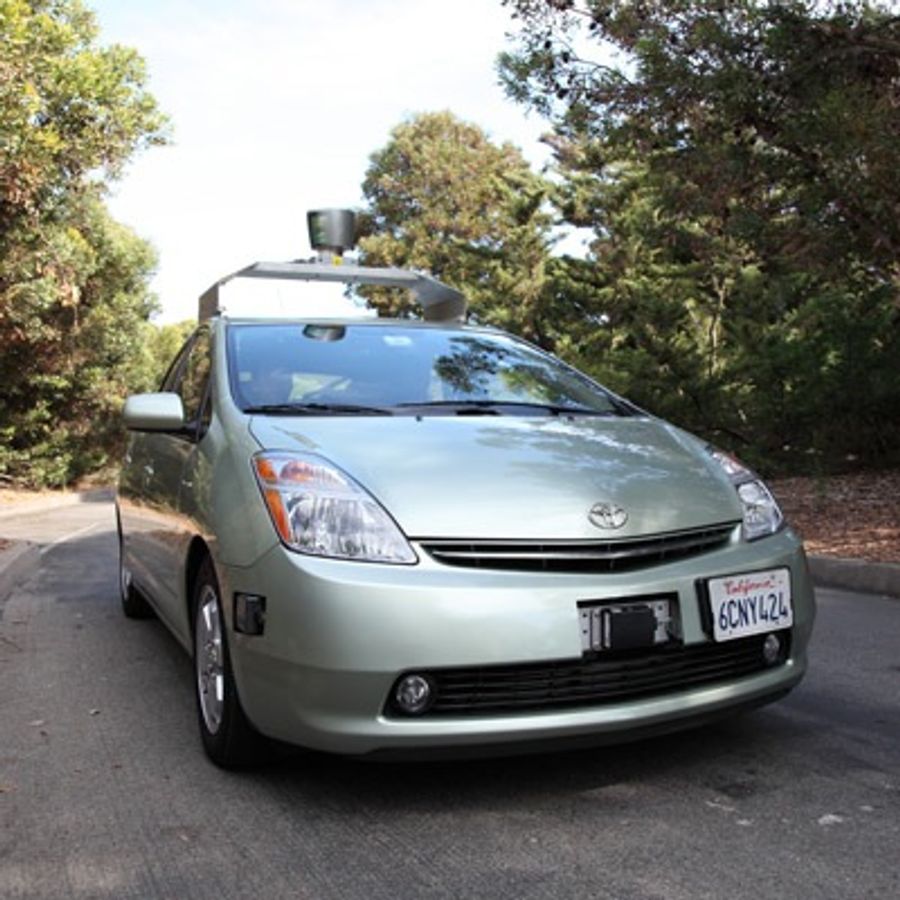 A light green car has a roof rack with a lidar module on top.
