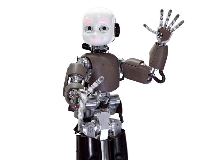 A child shaped robot with a shiny white head, camera eyes and glowing pink lights for eyebrows and smile waves at the camera.