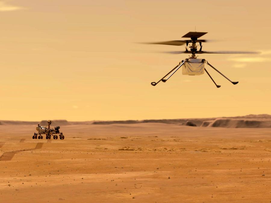 A large ground rover and a small flying helicopter are seen on Mars.