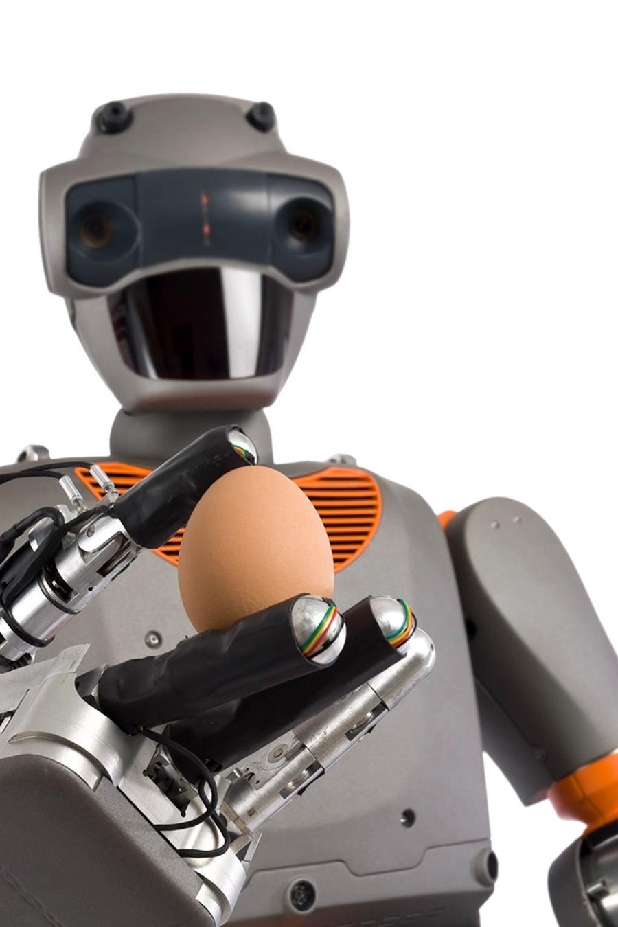 The robot grips an egg between two of its four fingers.