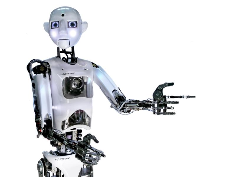 An expressive humanoid robot with a bright round face, a shiny torso with sensors, and two arms with black jointed fingers.
