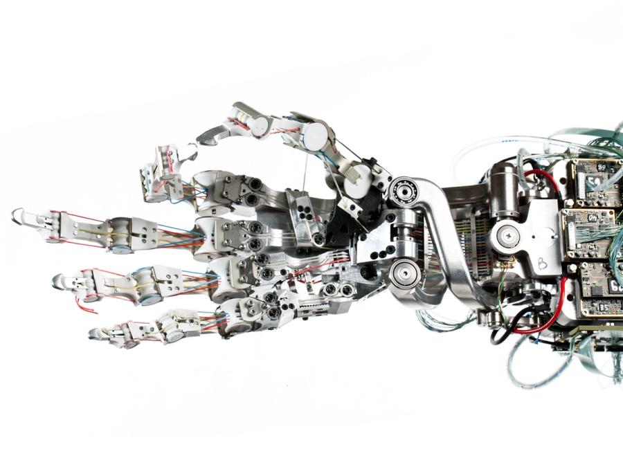 Close-up of the uncovered robotic hand shows the thumb and index finger pinched together.
