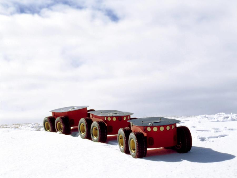 Three Pioneer 3 bases, each with four wheels, travel in a row through a snowy landscape.