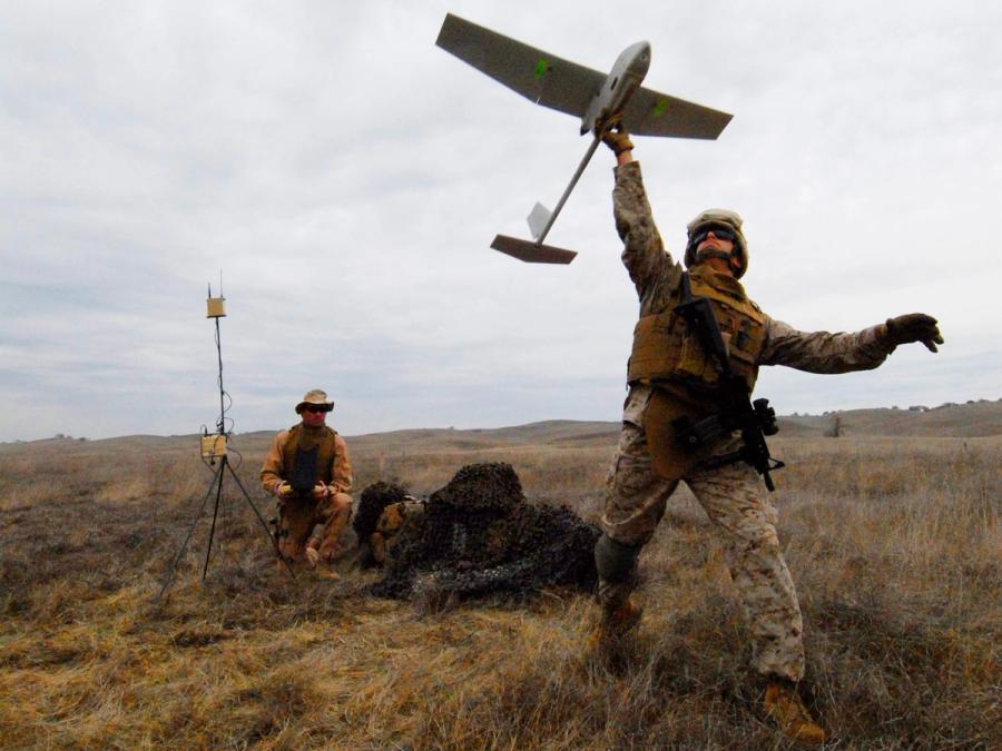 A US Soldier prepares to launch an unmanned aircraft from one hand.