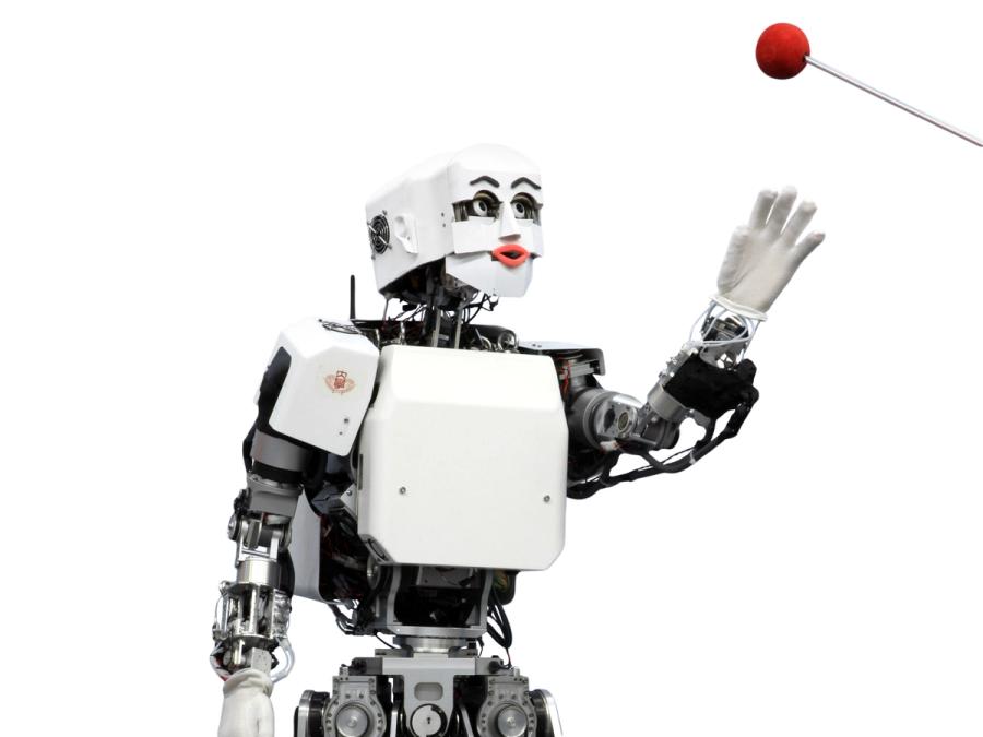A cartoonish humanoid robot with an expressive face reaches towards a red ball on a stick.
