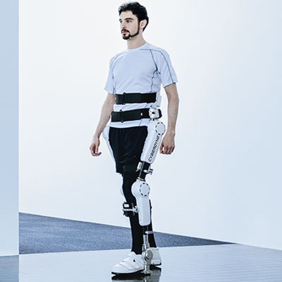 A bearded man wears a white exoskeleton suit on his legs.