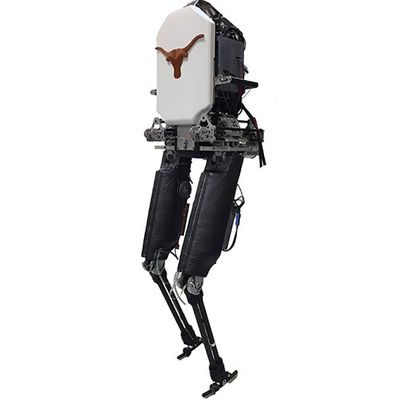 A bipedal robot with black legs and a white torso emblazoned with a longhorn silhouette poses mid-step.