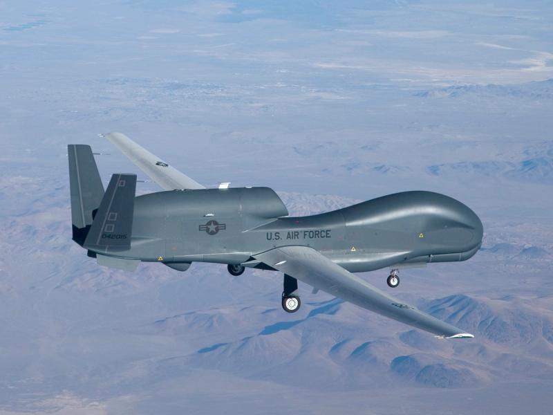 The Global Hawk unmanned aerial vehicle is the size of a plane with a similar shape including a curved front, wings and stabilizers seen in flight.