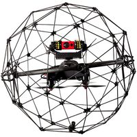 A black drone with electronics sits in the middle of a protective spherical carbon fiber cage.