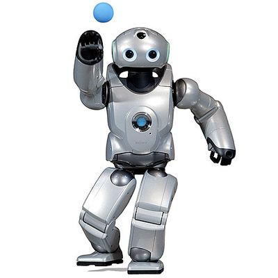 A silver humanoid with two big blue eyes on a rounded head. A small blue ball is being expelled from one of its hands and it stands in an active pitching pose.