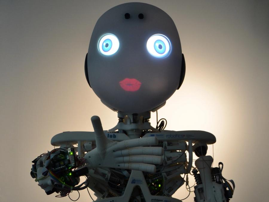 The robot is seen in the dark so that its blue eyes and red lips glow.