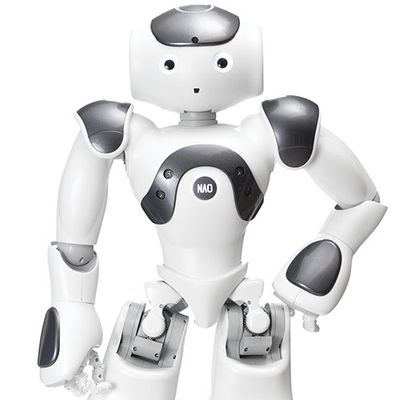 Nao is a friendly, cartoonish, white and silver humanoid robot stands with one hand on it's hip. It has two eyes and a small hole with forms its mouth.