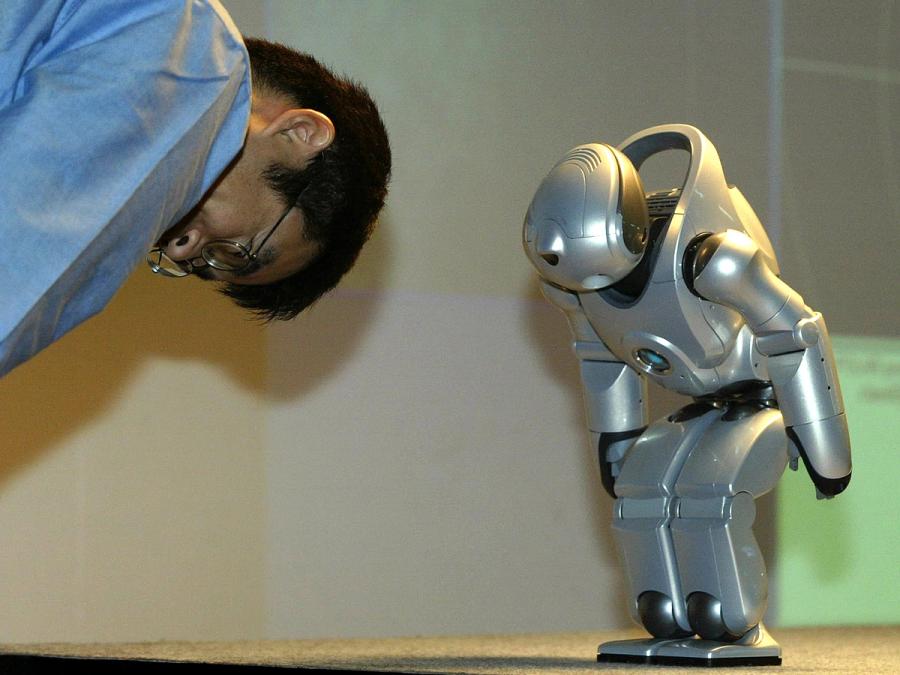 A man and the robot bow to each other.