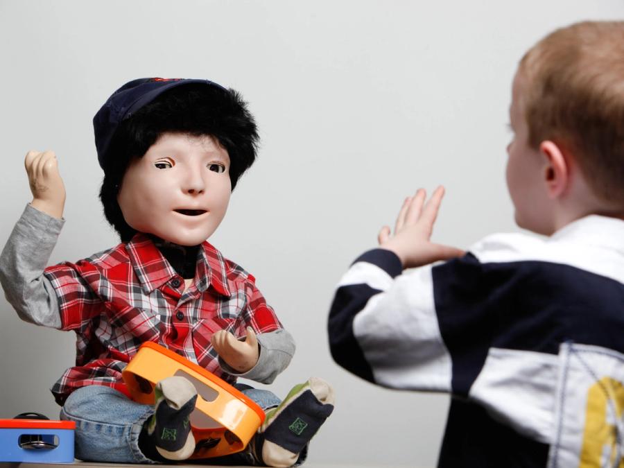 A child and the child-like robot mirror each others motions.
