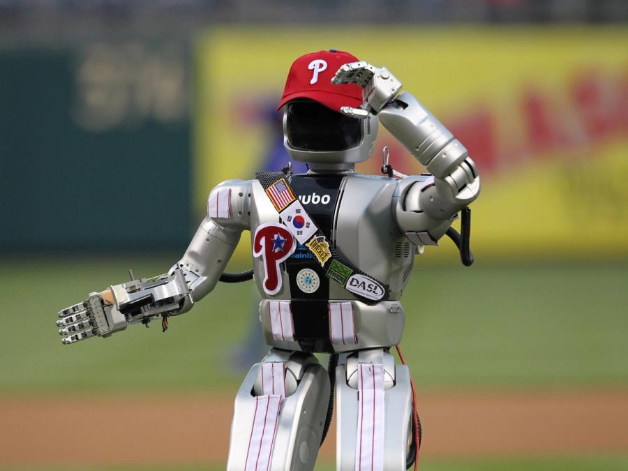 The robot stands on a baseball field wearing a Phillies cap and parts of a uniform.