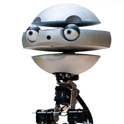 A silver robotic head consisting of three spherical segments with eyeballs and divots forming the appearance of eyebrows and a mouth.