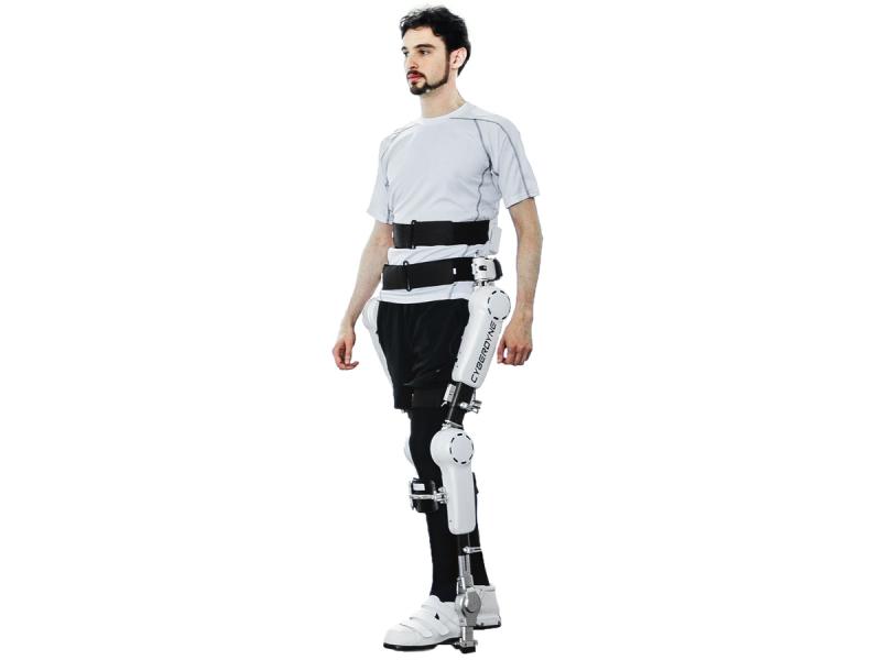 A man poses in a waist down exoskeleton suit that goes down each leg and connects under the foot.