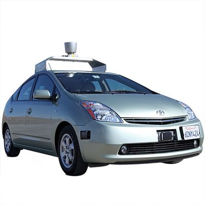 A car with cameras, radar, and a roof rack holding a large lidar instrument.