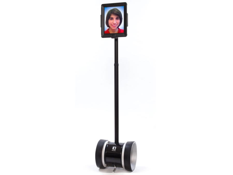 A wheeled telepresence robot with a long neck holding a monitor showing a smiling face.