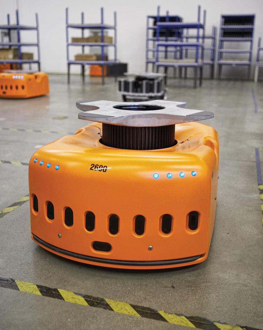An orange boxy robot with a protruding circular apparatus.