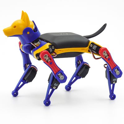 A miniature robot dog with a yellow head, black torso and red and blue neck and limbs.