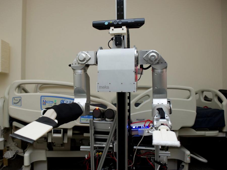 A robot in front. ofa hospital bed.