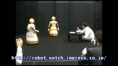 Wakamaru robots perform on stage.