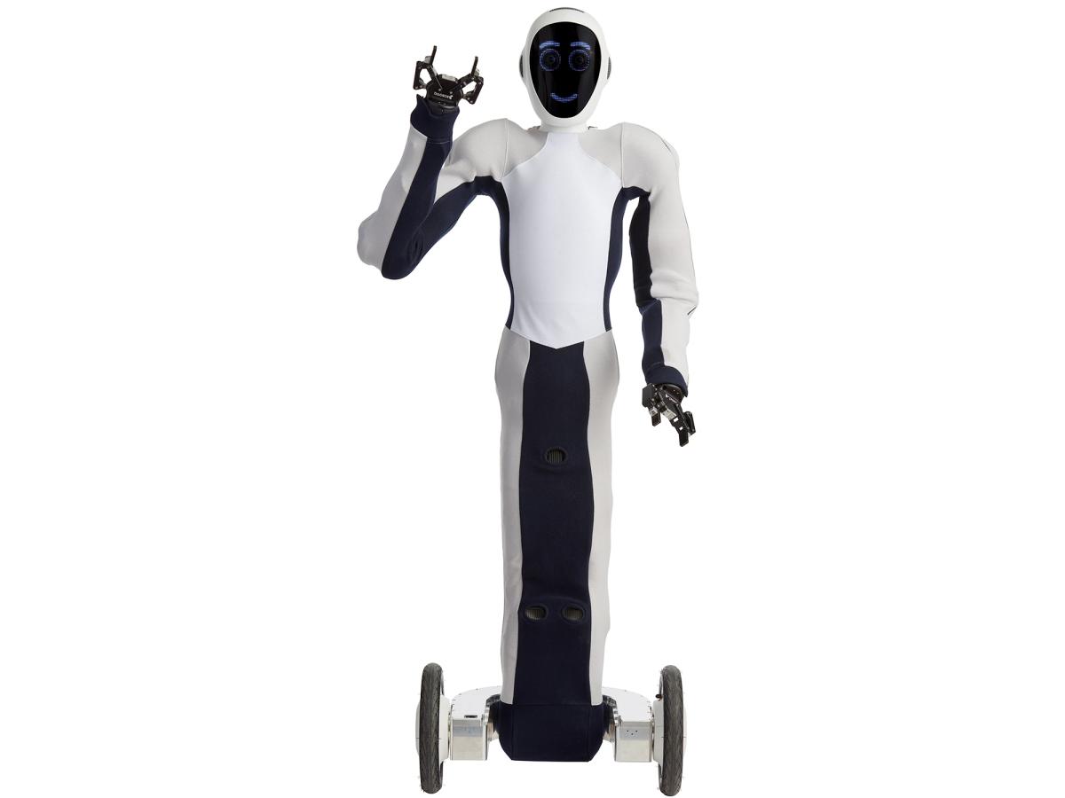 EVE, a black and white soft humanoid on a dual wheel platform, with a face displaying blue circles for eyes, and a smile. One of it's two gripper hands is raised in a greeting.
