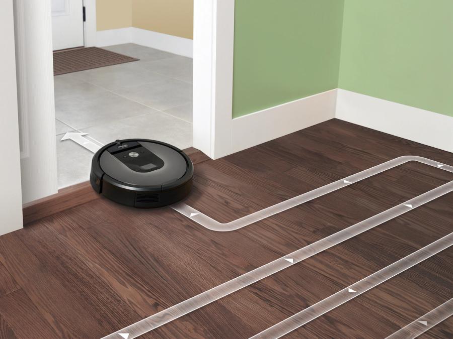 A photo-illustration shows the robot in action cleaning a house with white arrows and lines showing its path.