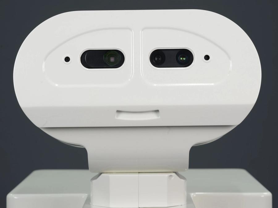 Close-up of the robots simple face, which is oval shaped, and includes eyes with cameras inside, additional sensors, and the shape of a smiling mouth.