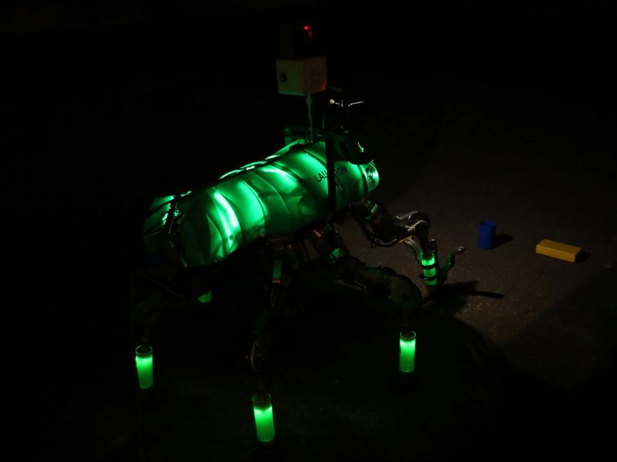 A pitch black image shows parts of the robot glowing green.