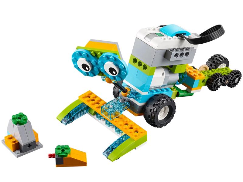 A simple collection of Lego bricks form a cute robotic shape with wheels, a power brick and two big eyes.