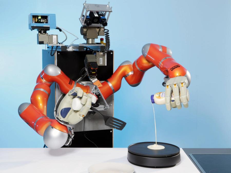 A robot with two advanced industrial arms pours batter onto a hotplate with one four fingered hand, and holds a spatula with the other.