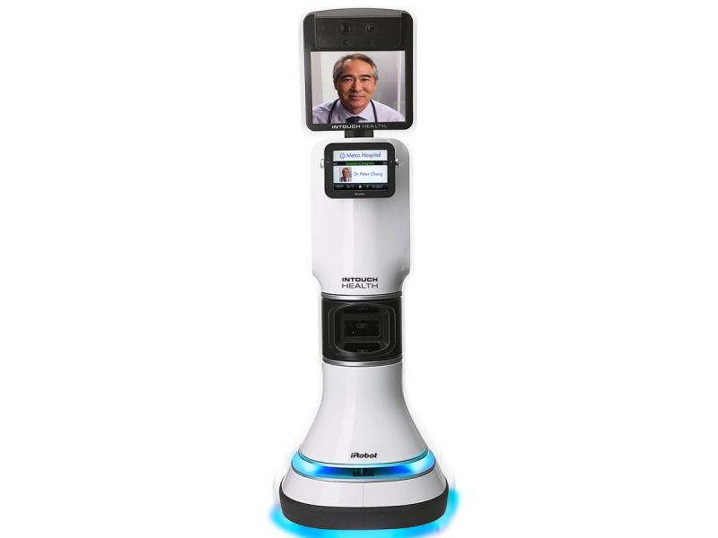 A telepresence robot with blue glowing lights on the wheeled base , a thick trunk with a touchscreen and electronics, and a large display on top which shows a doctor's face.