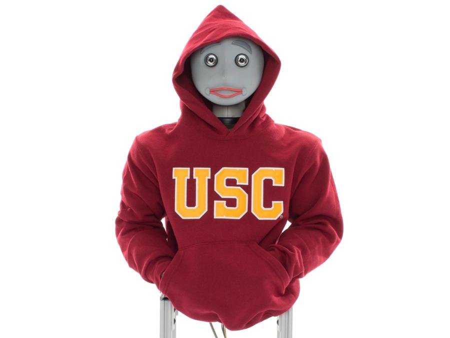 A humanoid robot wears a red hoodie labelled USC.