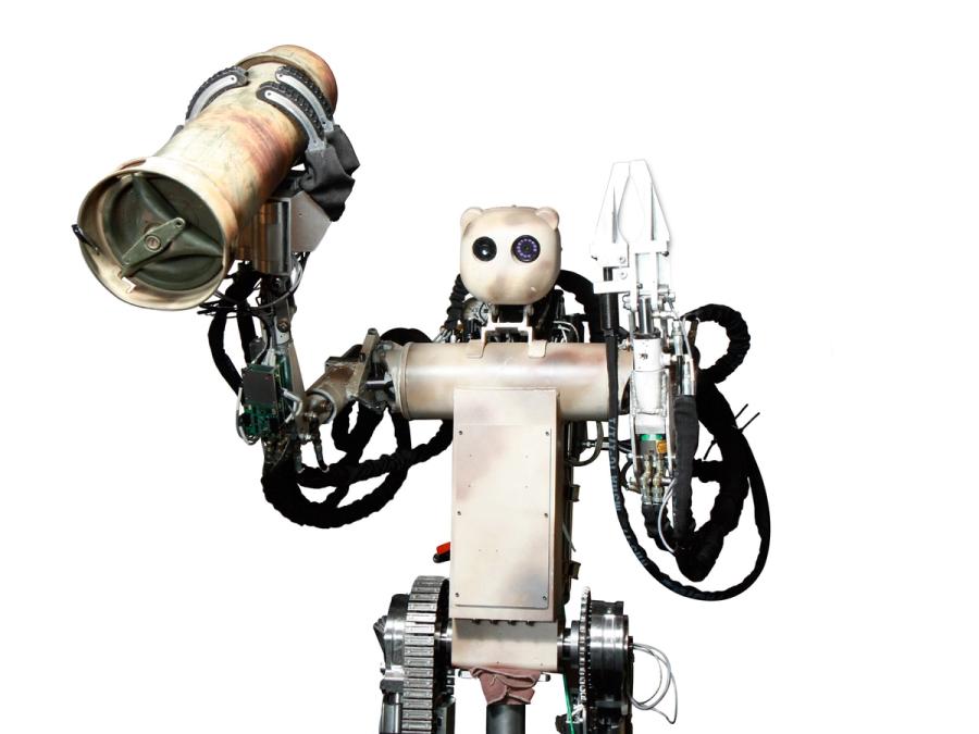 The robot holds up a metal cannister.